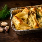 Golden pull-apart garlic bread with dill and garlic in a baking pan