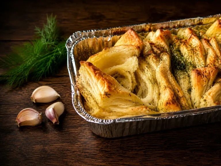 Golden pull-apart garlic bread with dill and garlic in a baking pan